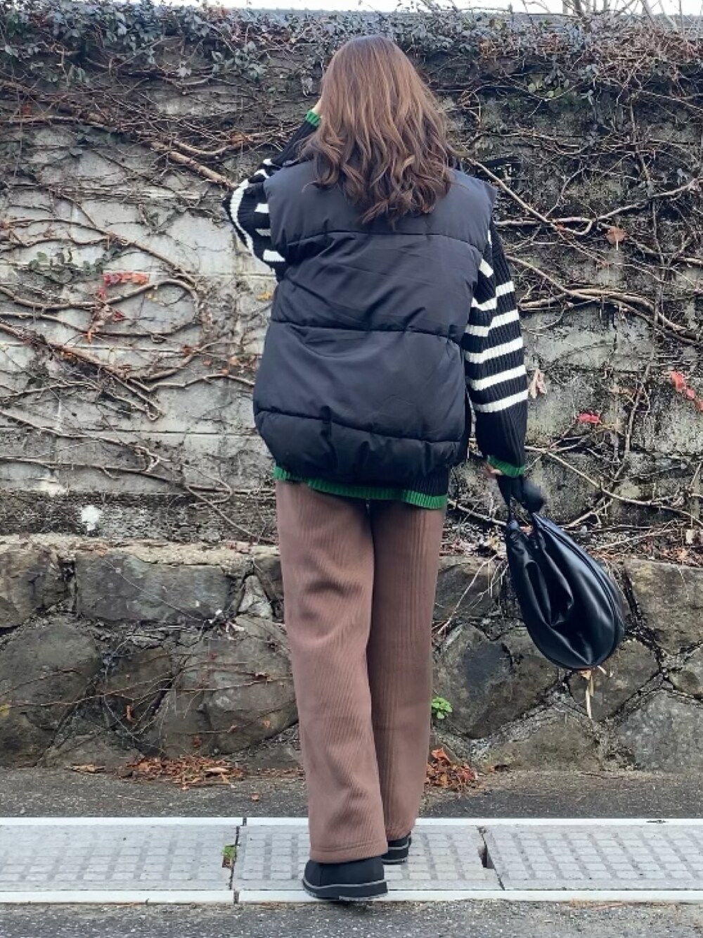 ブラウン系のその他パンツ、ブラック系のニット/セーター、ブラック系のバッグを着用したレディースの冬コーディネートの3枚目の写真