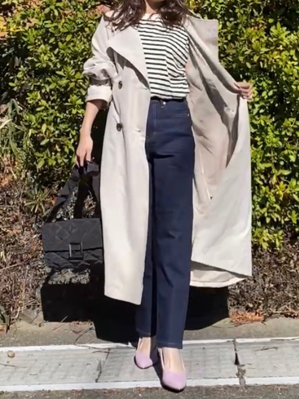 ベージュ系のトレンチコート、ブラック系のTシャツ/カットソーを着用したレディースの冬コーディネートの2枚目の写真