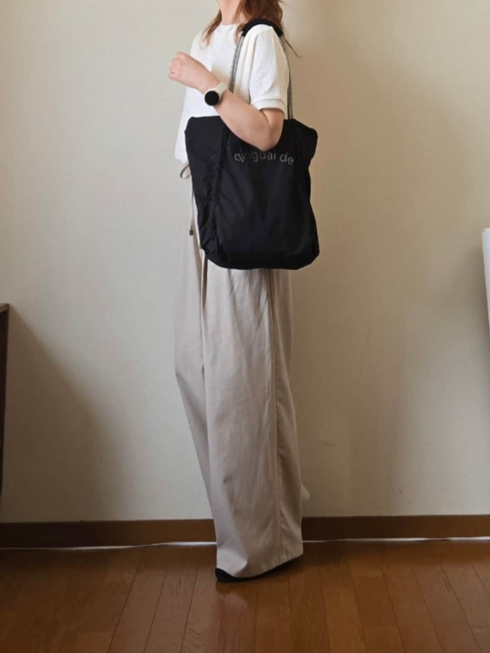 ホワイト系のTシャツ/カットソー、ベージュ系のその他パンツ、ブラック系のトートバッグを着用したレディースの夏コーディネートの3枚目の写真