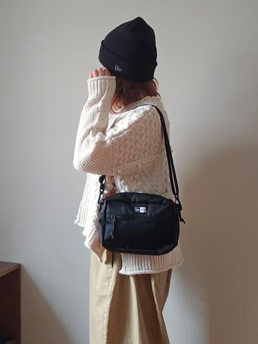 ブラック系のショルダーバッグ、ベージュ系のその他パンツ、ホワイト系のニット/セーターを着用したレディースの冬コーディネートの4枚目の写真