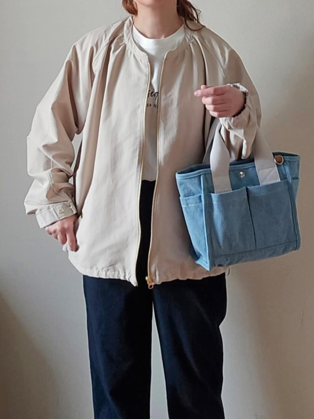 ブルー系のその他パンツ、ホワイト系のマウンテンパーカー、ブルー系のトートバッグを着用したレディースの春コーディネートの3枚目の写真