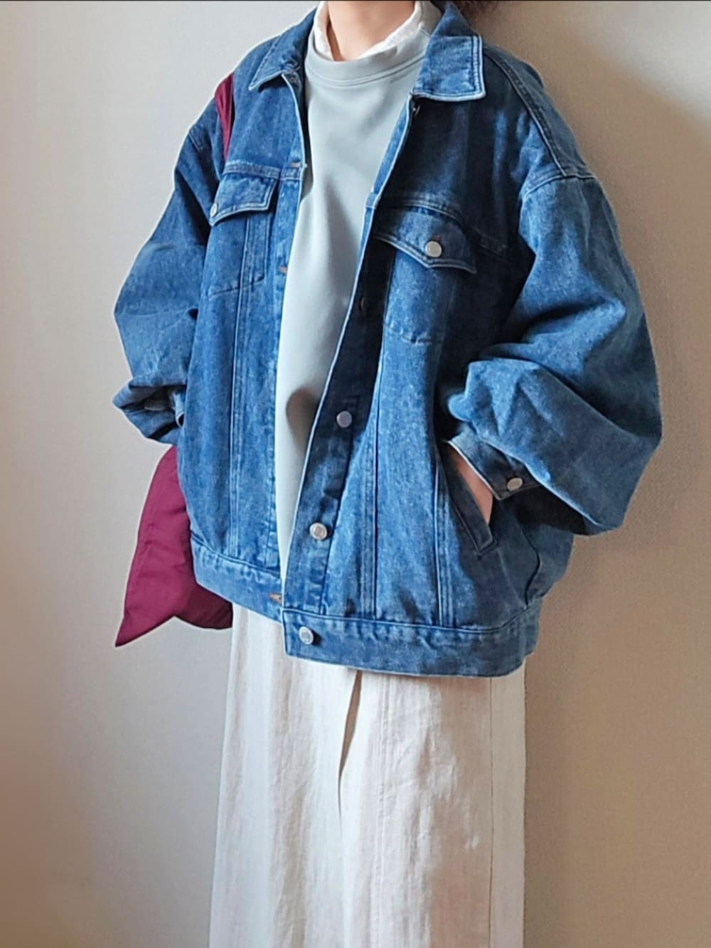 ブルー系のデニムジャケット、グリーン系のスウェット、ベージュ系のその他パンツを着用したレディースの春コーディネートの3枚目の写真