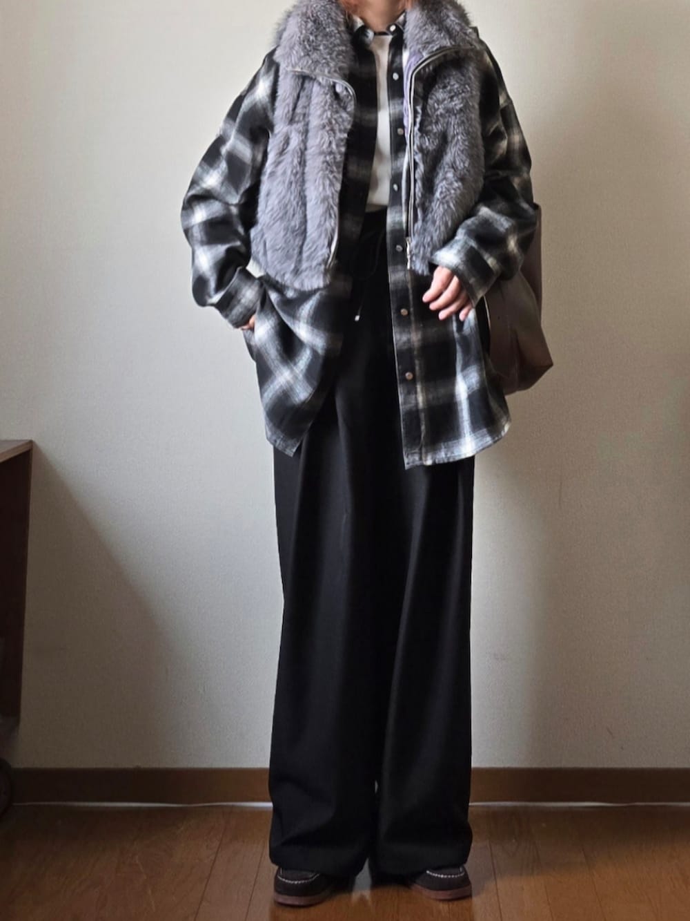 グレー系のベスト、ブラック系のシャツ/ブラウス、ブラック系のスラックスを着用したレディースの冬コーディネートの2枚目の写真