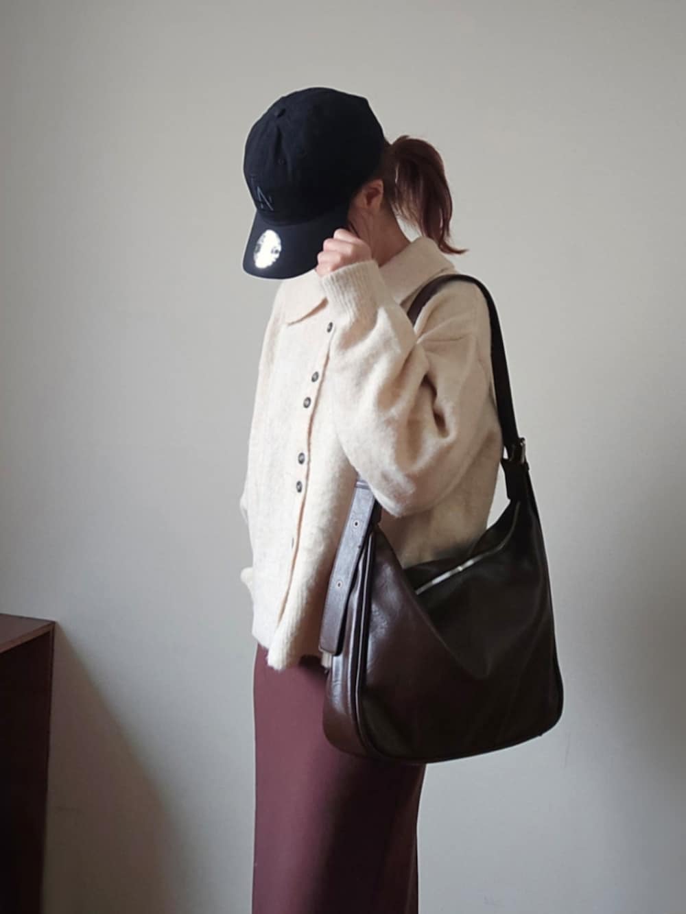 ホワイト系のその他アウター、ブラウン系のスカート、ブラウン系のショルダーバッグを着用したレディースの秋コーディネートの3枚目の写真