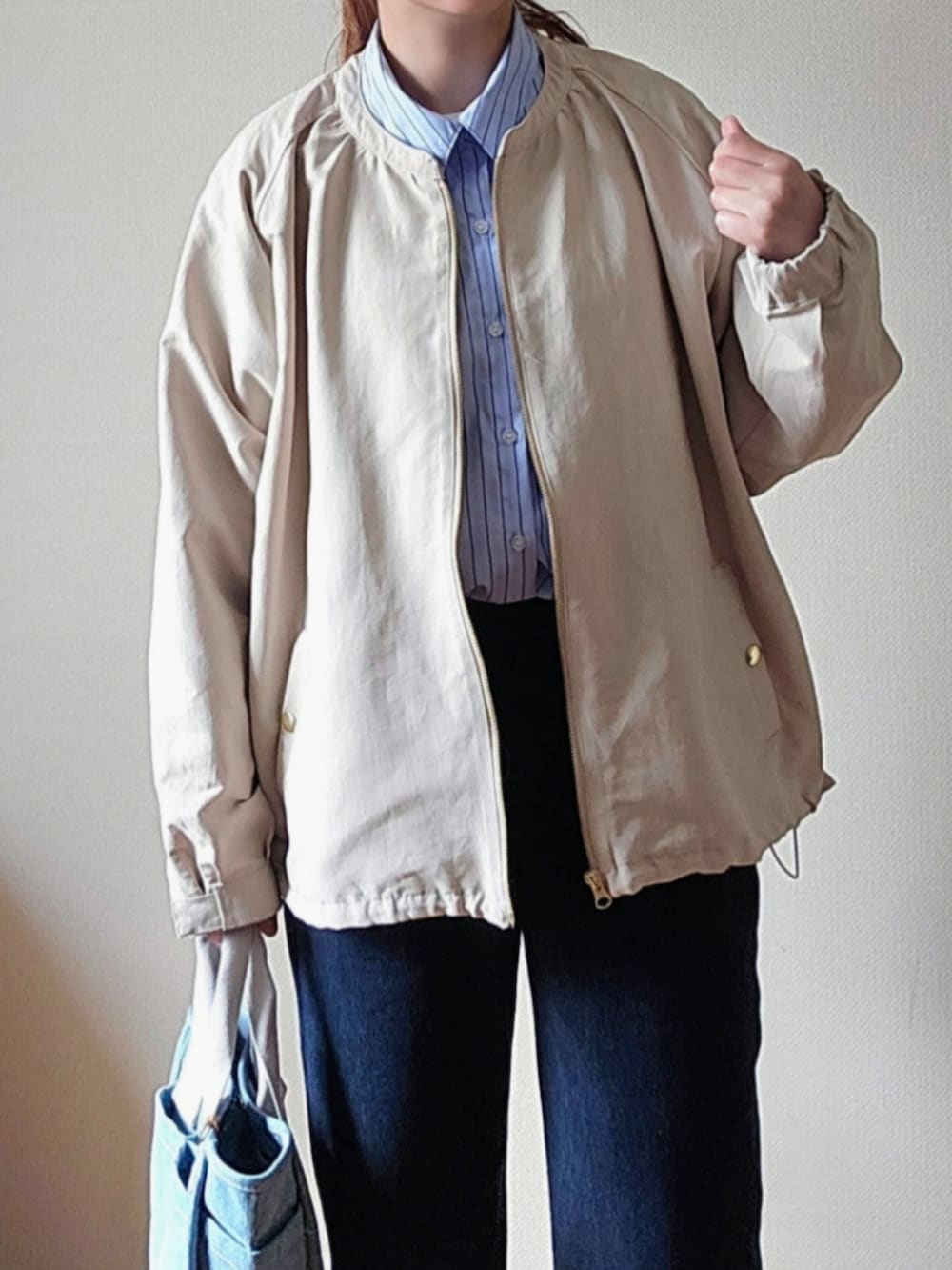 ブルー系のその他パンツ、ホワイト系のマウンテンパーカー、ブルー系のトートバッグを着用したレディースの春コーディネートの4枚目の写真