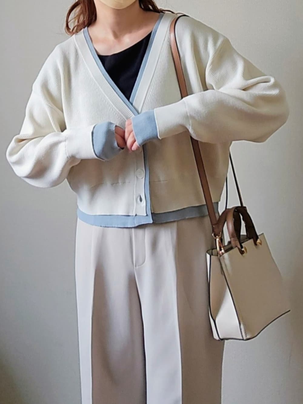 ベージュ系のトレンチコート、ホワイト系のカーディガン/ボレロ、ブラック系のパンプスを着用したレディースの春コーディネートの4枚目の写真