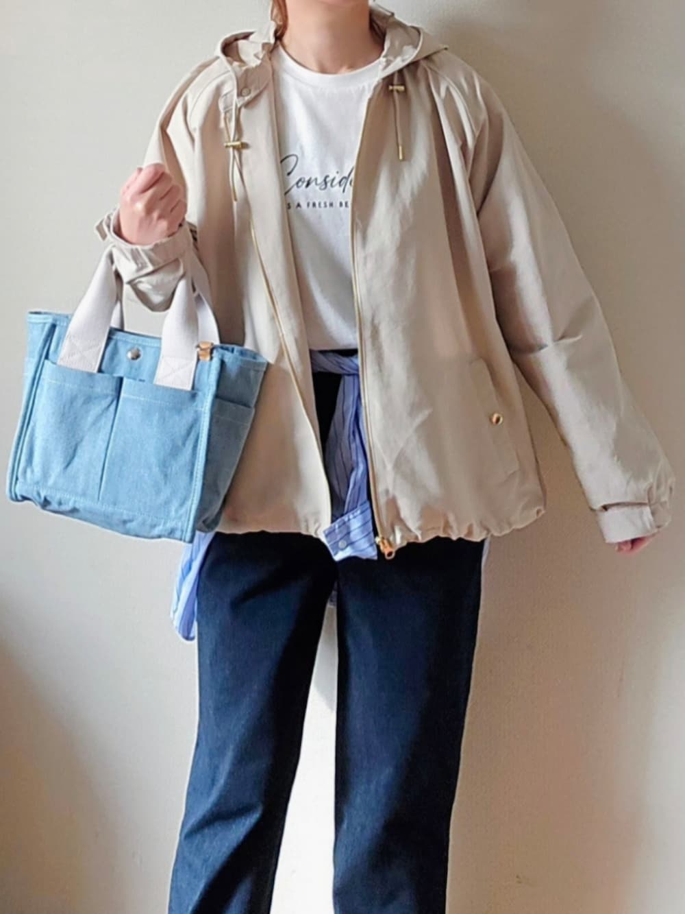 ブルー系のその他パンツ、ホワイト系のマウンテンパーカー、ブルー系のトートバッグを着用したレディースの春コーディネートの2枚目の写真