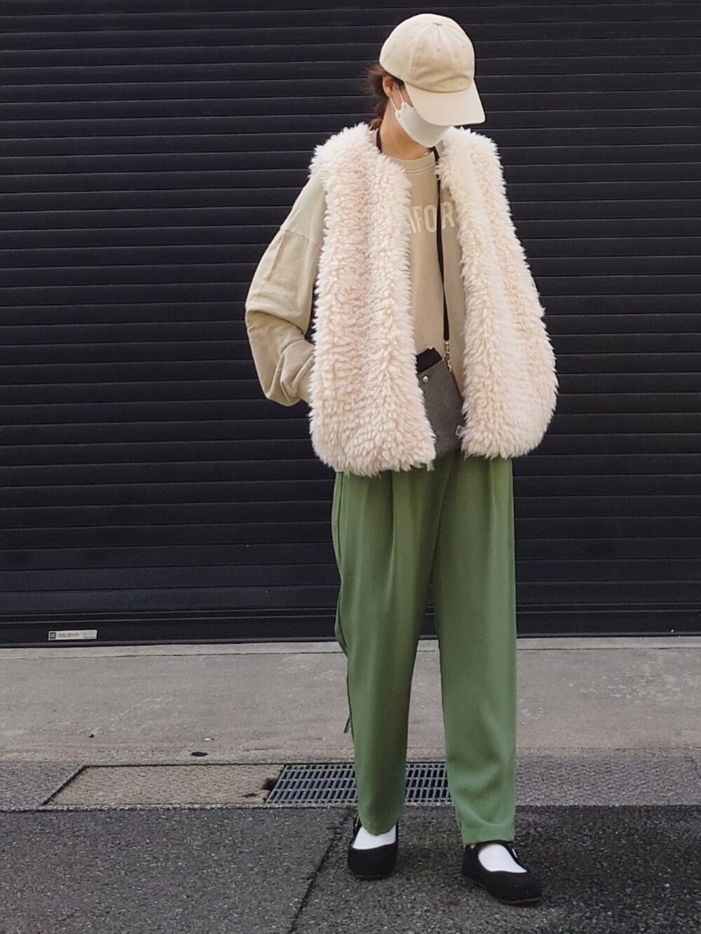 ホワイト系のベスト、ベージュ系のその他トップス、グリーン系のスラックスを着用したレディースの秋コーディネートの3枚目の写真