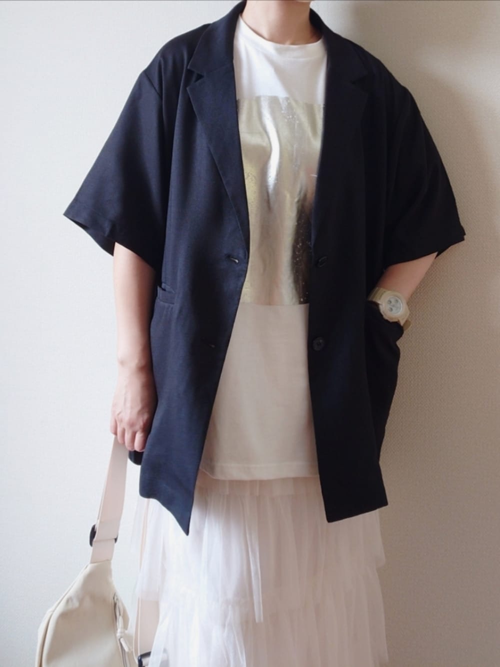 ブラック系のテーラードジャケット、ホワイト系のTシャツ/カットソー、ホワイト系のスカートを着用したレディースの夏コーディネートの3枚目の写真