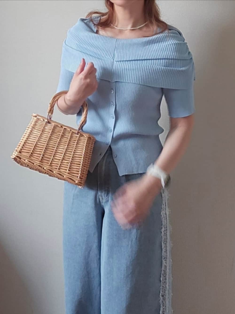 ブルー系のニット/セーター、ブルー系のデニムパンツ、ブラウン系のサンダルを着用したレディースの夏コーディネートの4枚目の写真