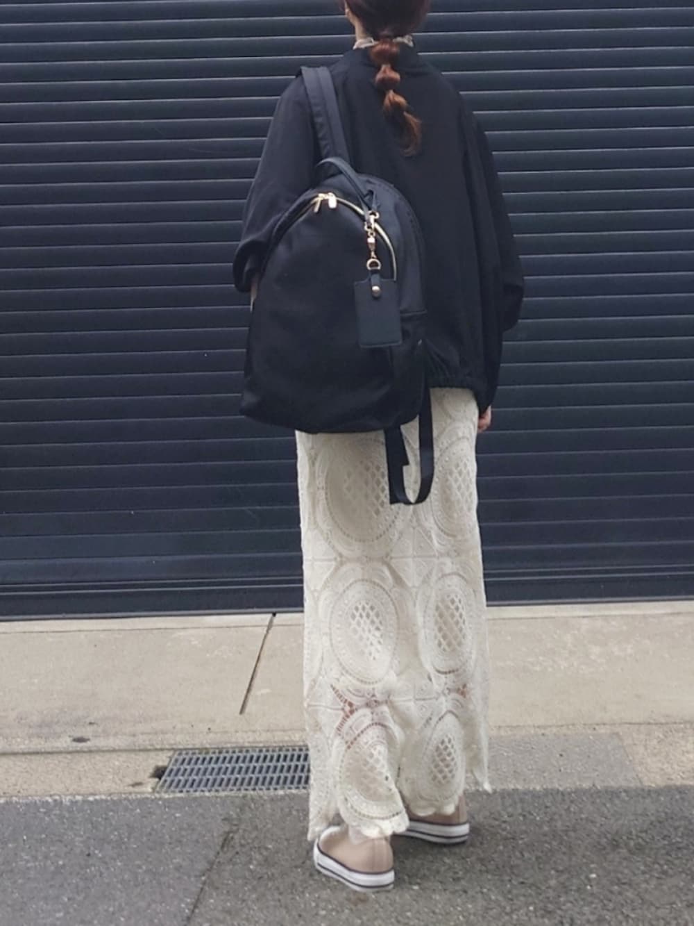 ブラック系のブルゾン、ホワイト系のワンピース、ピンク系のTシャツ/カットソーを着用したレディースの春コーディネートの3枚目の写真