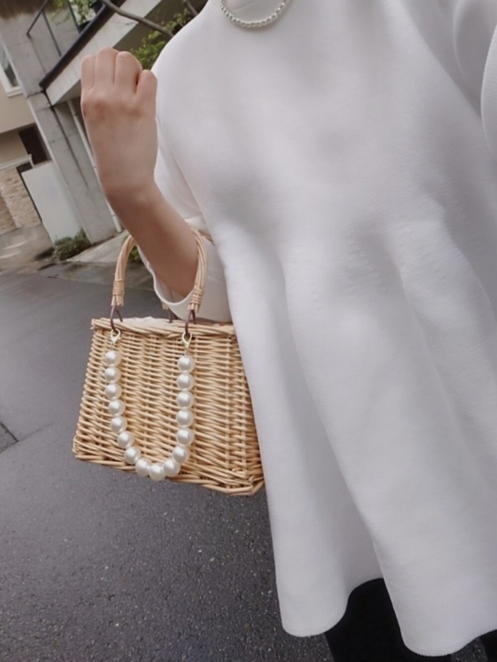 ホワイト系のニット/セーター、ベージュ系のかごバッグ、ブラック系のバレエシューズを着用したレディースの春コーディネートの5枚目の写真