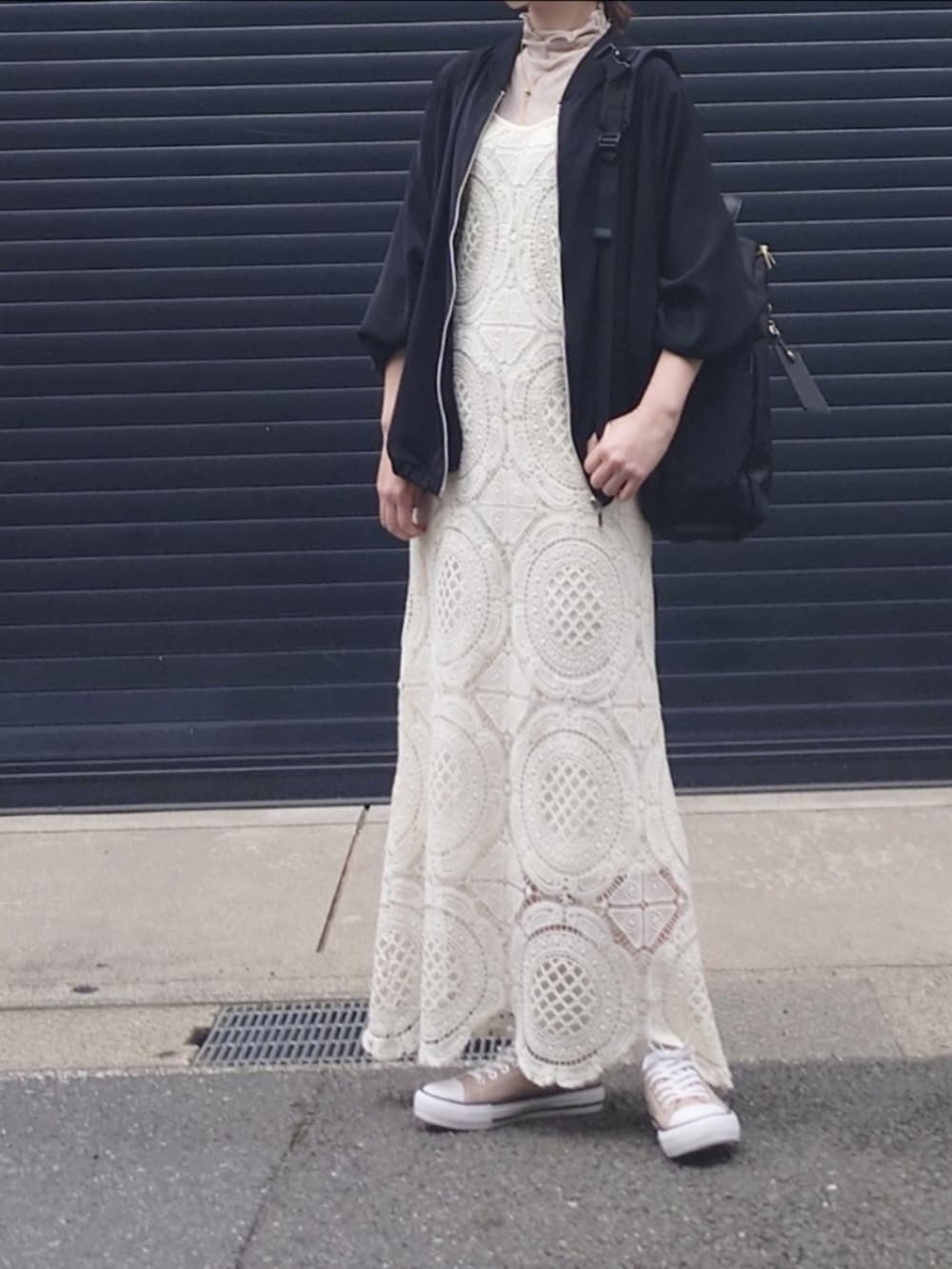 ブラック系のブルゾン、ホワイト系のワンピース、ピンク系のTシャツ/カットソーを着用したレディースの春コーディネートの2枚目の写真