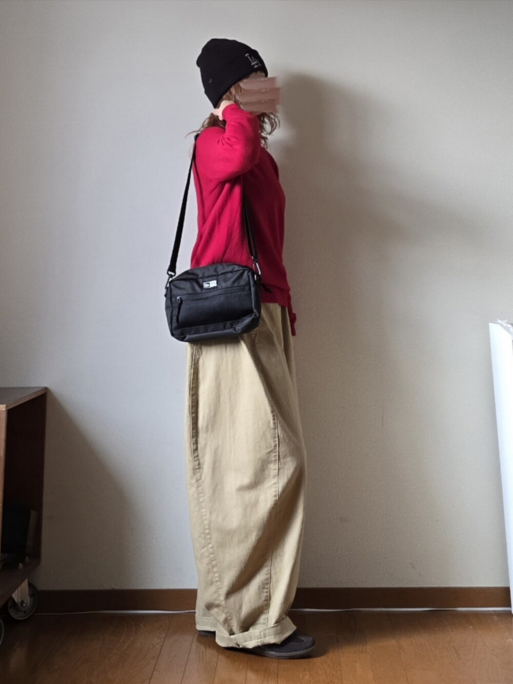 ブラック系のショルダーバッグ、レッド系のニット/セーター、ベージュ系のその他パンツを着用したレディースの冬コーディネートの3枚目の写真
