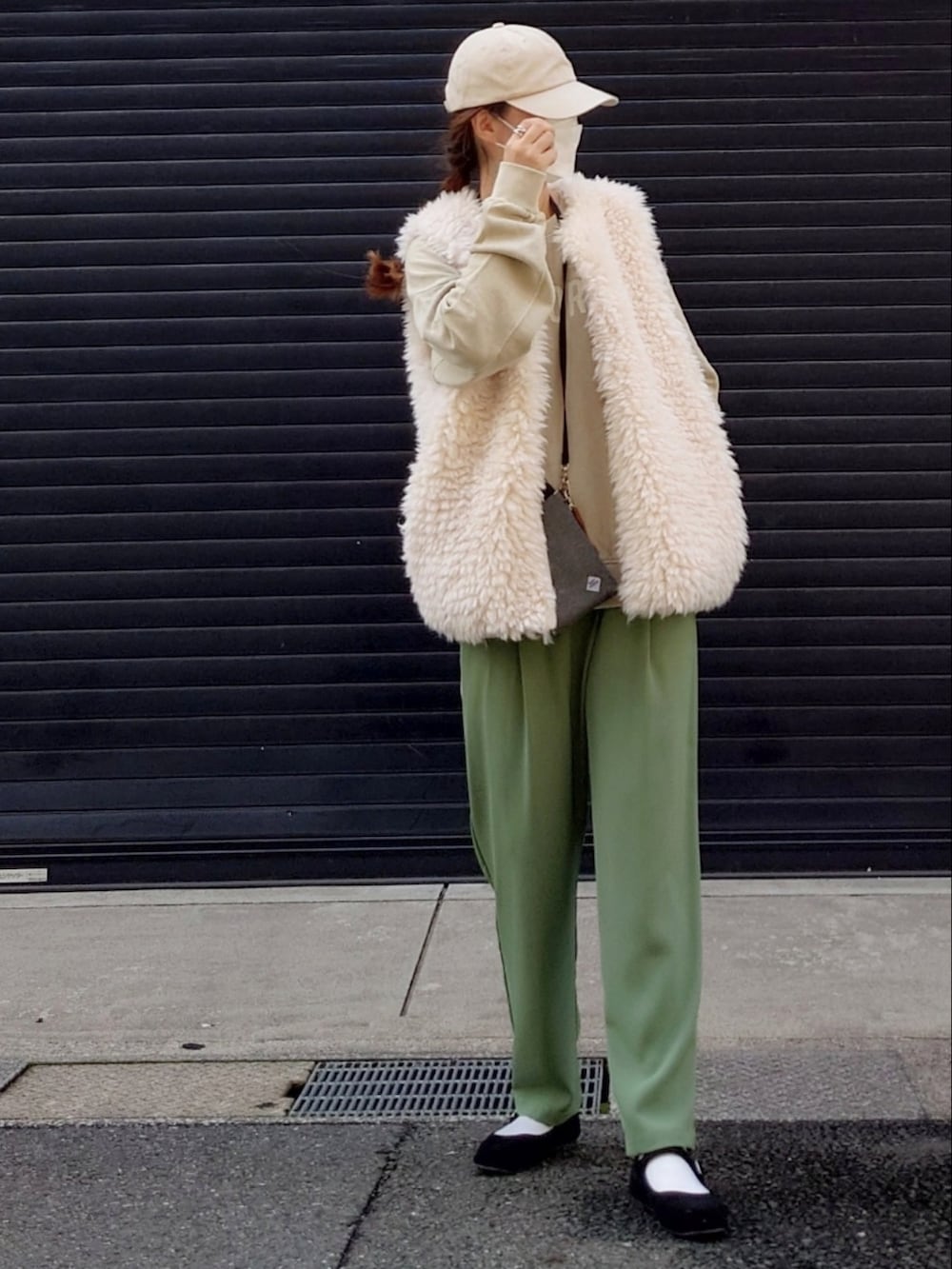 ホワイト系のベスト、ベージュ系のその他トップス、グリーン系のスラックスを着用したレディースの秋コーディネートの2枚目の写真