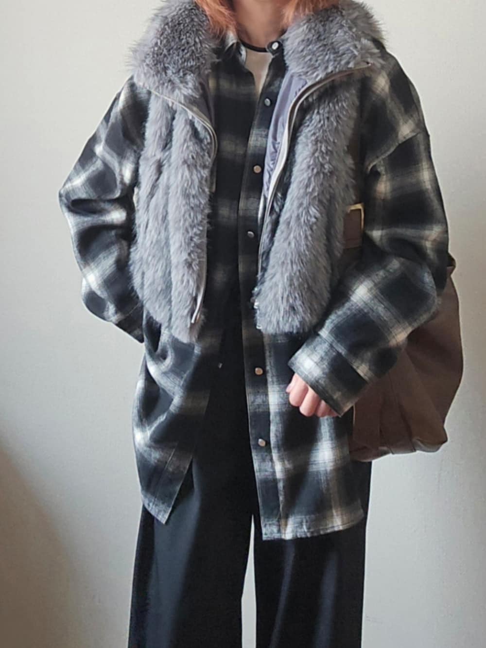 グレー系のベスト、ブラック系のシャツ/ブラウス、ブラック系のスラックスを着用したレディースの冬コーディネートの3枚目の写真