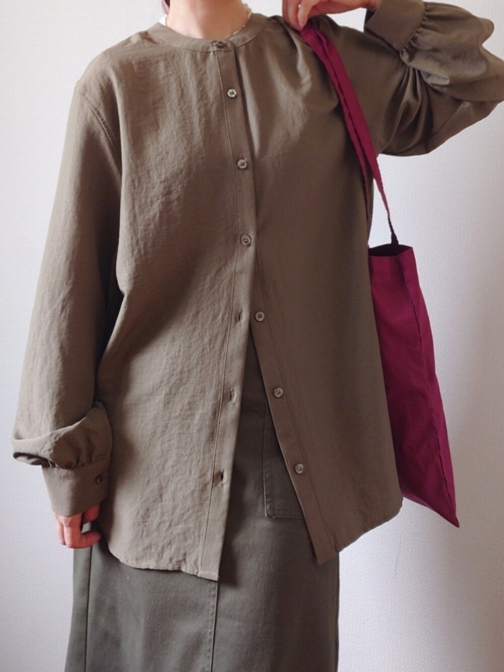 グリーン系のシャツ/ブラウス、グリーン系のスカート、ホワイト系のTシャツ/カットソーを着用したレディースの秋コーディネートの3枚目の写真