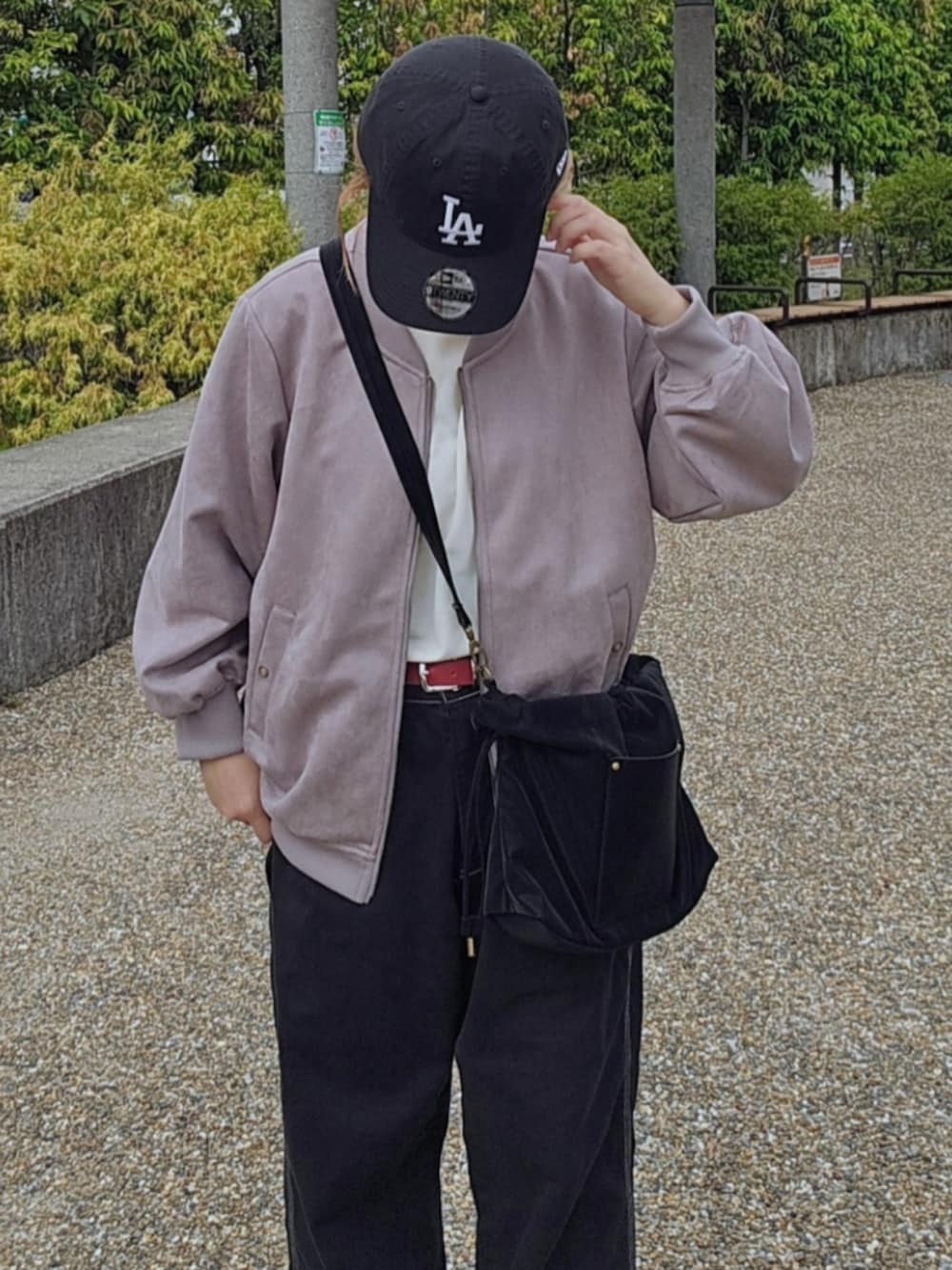 グレー系のブルゾン、ブラック系のショルダーバッグ、ホワイト系のTシャツ/カットソーを着用したレディースの秋コーディネートの3枚目の写真