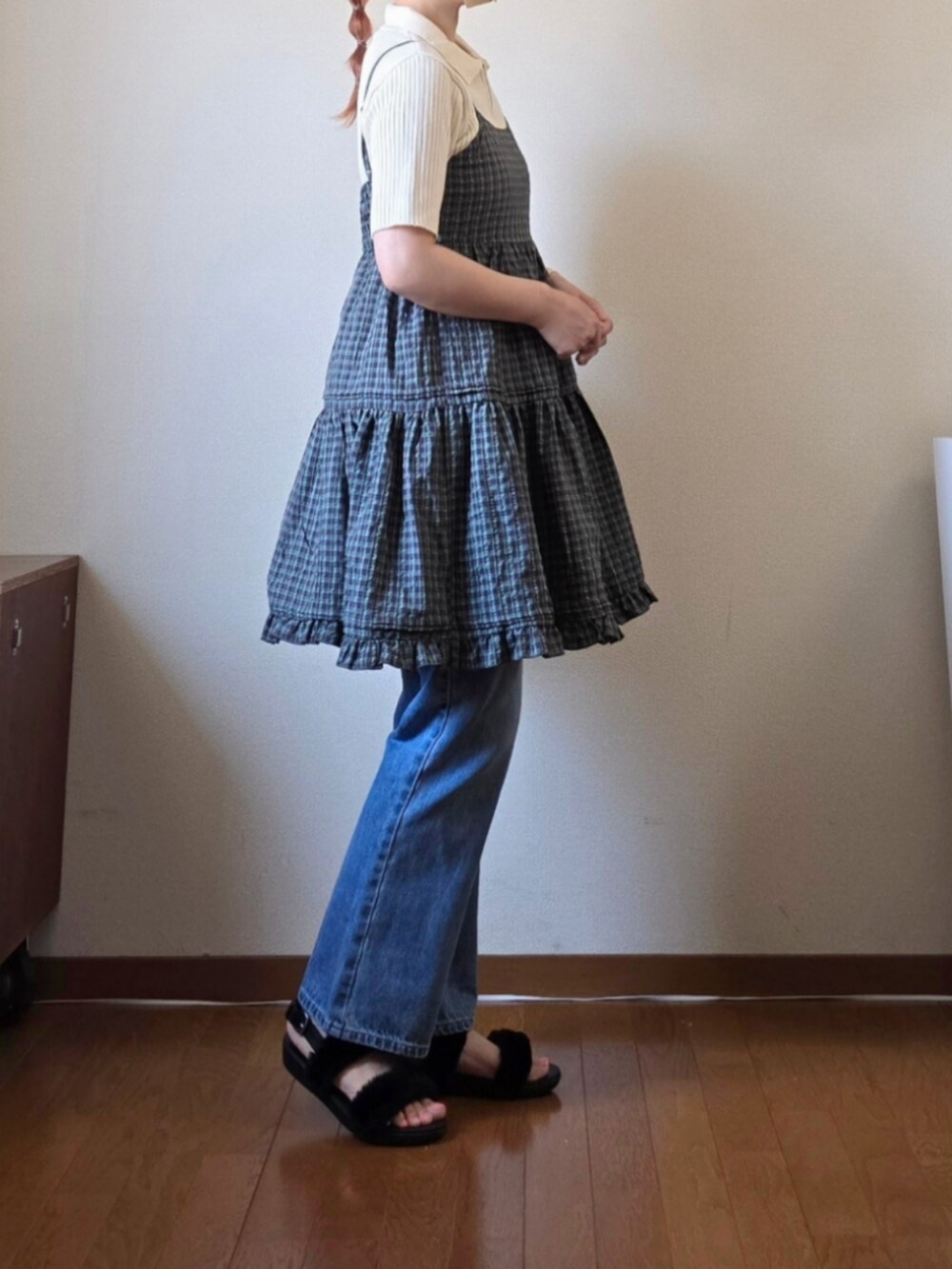 グレー系のチュニック、ホワイト系のニット/セーター、ブルー系のデニムパンツを着用したレディースの夏コーディネートの4枚目の写真