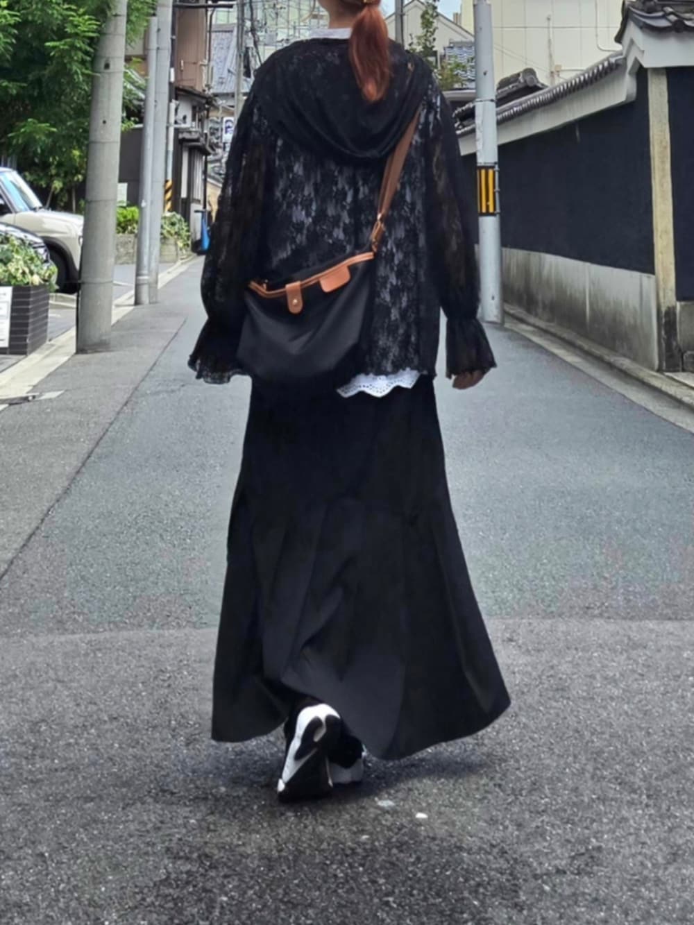 ブラック系のTシャツ/カットソー、ブラック系のショルダーバッグ、ブラック系のスニーカーを着用したレディースの秋コーディネートの3枚目の写真