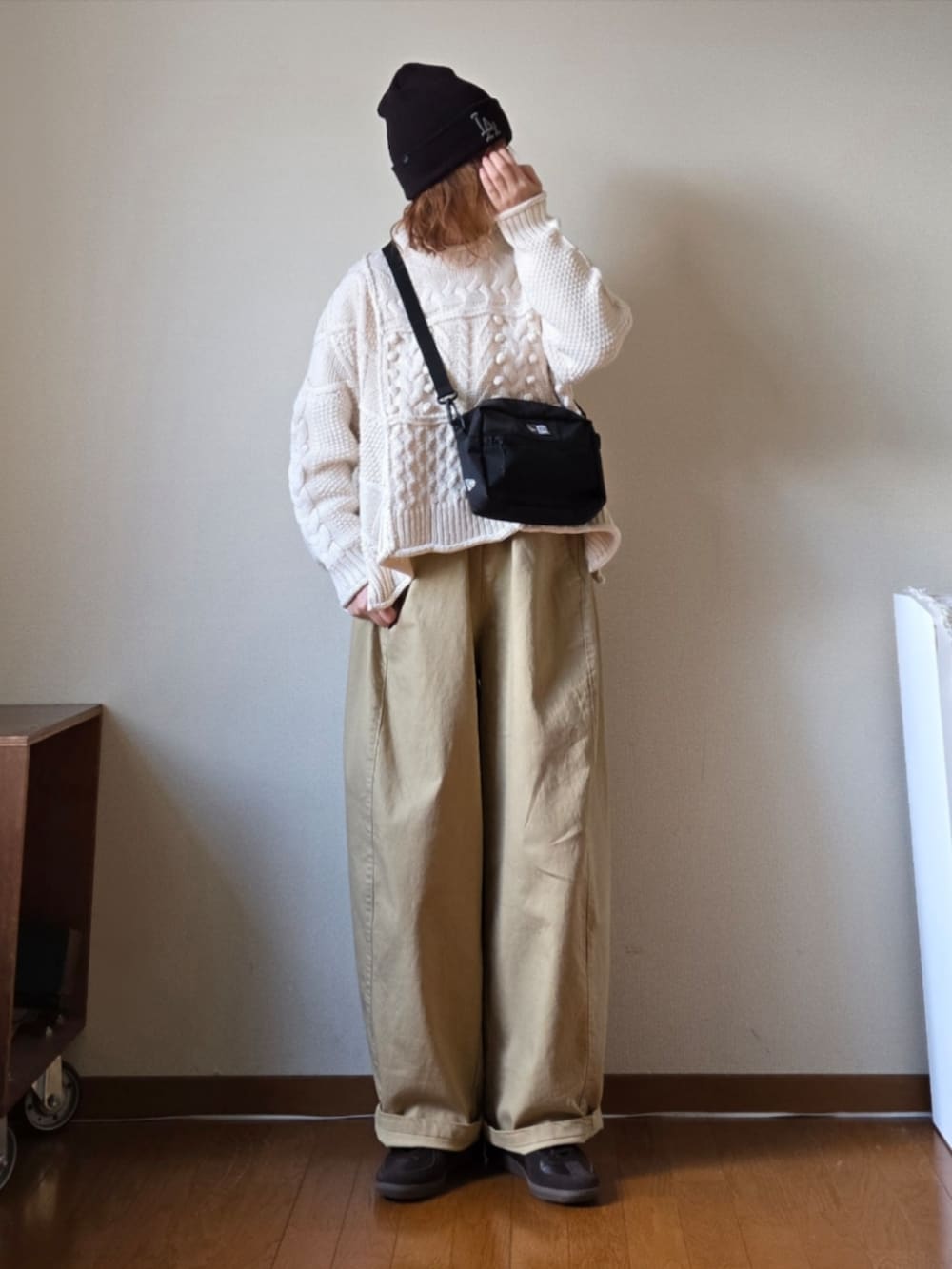 ブラック系のショルダーバッグ、ベージュ系のその他パンツ、ホワイト系のニット/セーターを着用したレディースの冬コーディネートの3枚目の写真