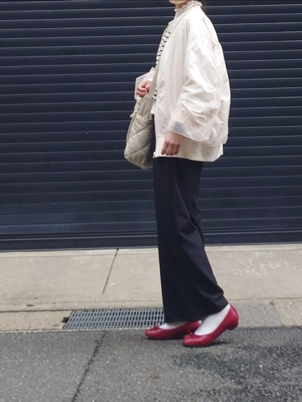 ホワイト系のブルゾン、ブラック系のスラックス、ホワイト系のカーディガン/ボレロを着用したレディースの春コーディネートの2枚目の写真