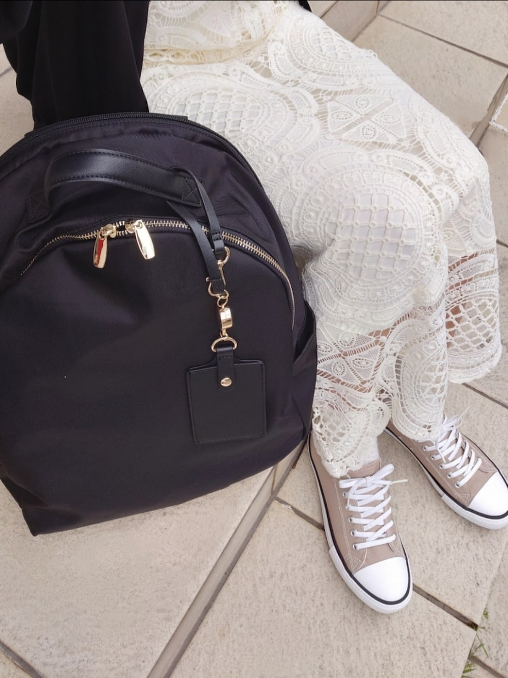 ブラック系のブルゾン、ホワイト系のワンピース、ピンク系のTシャツ/カットソーを着用したレディースの春コーディネートの4枚目の写真