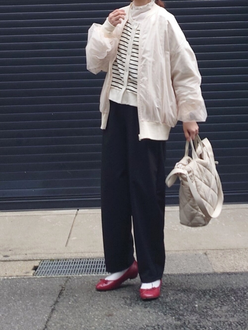 ホワイト系のブルゾン、ブラック系のスラックス、ホワイト系のカーディガン/ボレロを着用したレディースの春コーディネートの4枚目の写真
