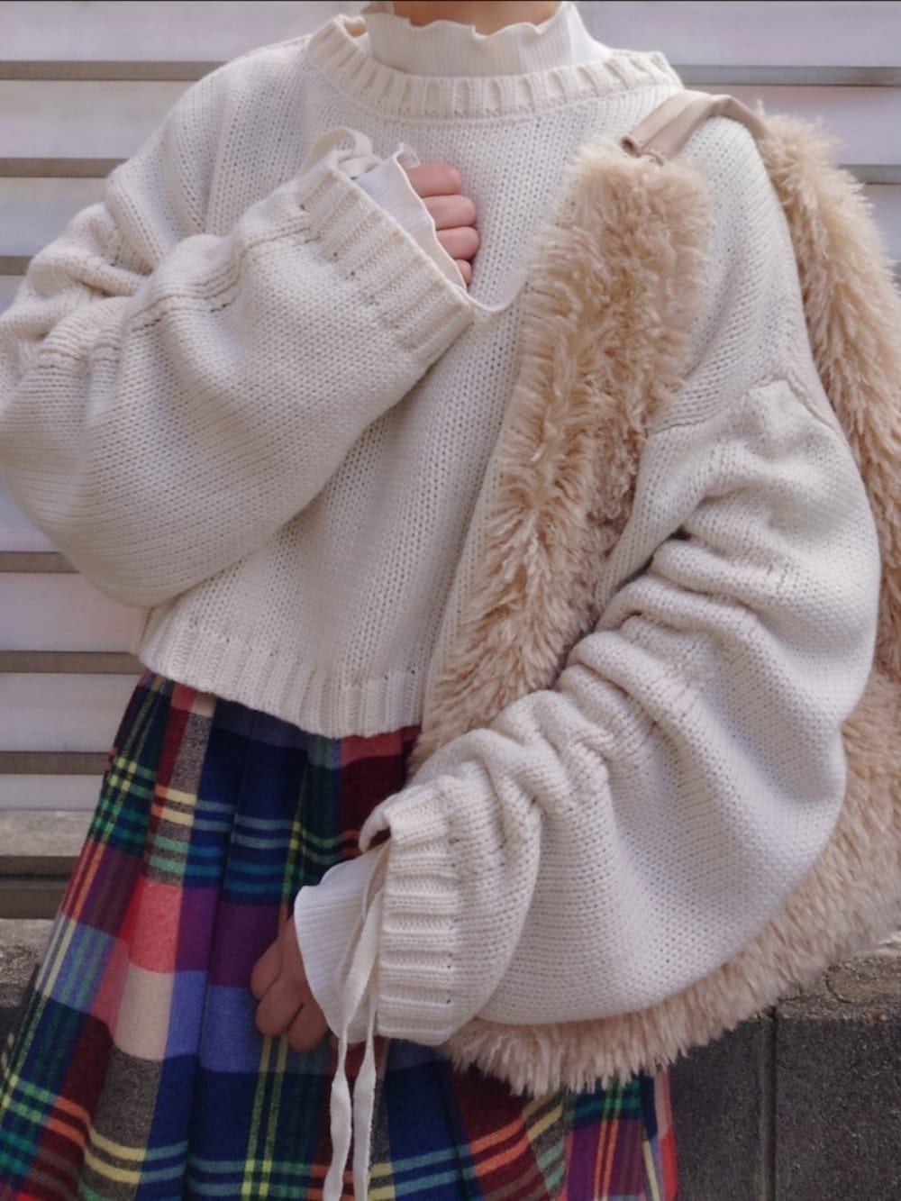 ホワイト系のニット/セーター、ホワイト系のTシャツ/カットソー、レッド系のワンピース/ドレスを着用したレディースの冬コーディネートの3枚目の写真