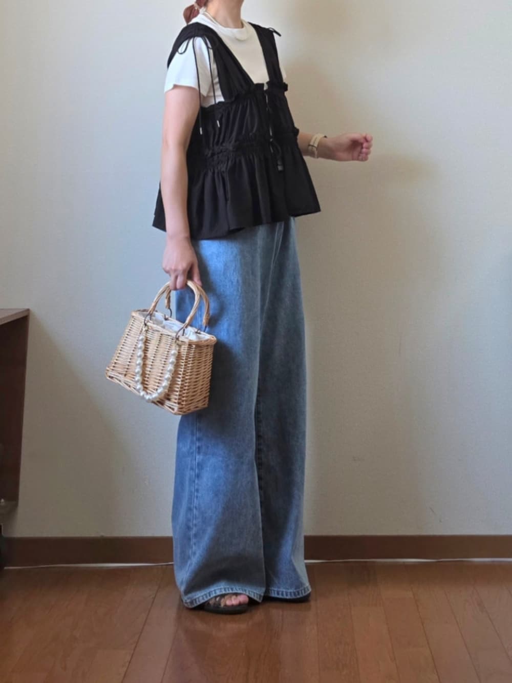 ブラック系のシャツ/ブラウス、ホワイト系のTシャツ/カットソー、ベージュ系のかごバッグを着用したレディースの夏コーディネートの4枚目の写真