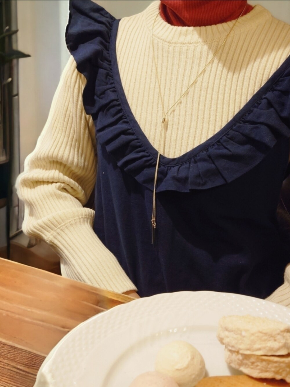 ホワイト系のニット/セーター、レッド系のTシャツ/カットソー、ブルー系のサロペット/オーバーオールを着用したレディースの冬コーディネートの2枚目の写真