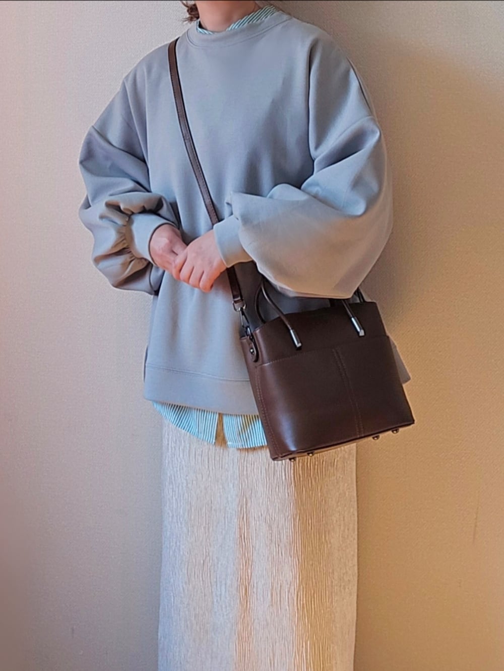 グリーン系のスウェット、グリーン系のシャツ/ブラウス、ホワイト系のスカートを着用したレディースの冬コーディネートの5枚目の写真