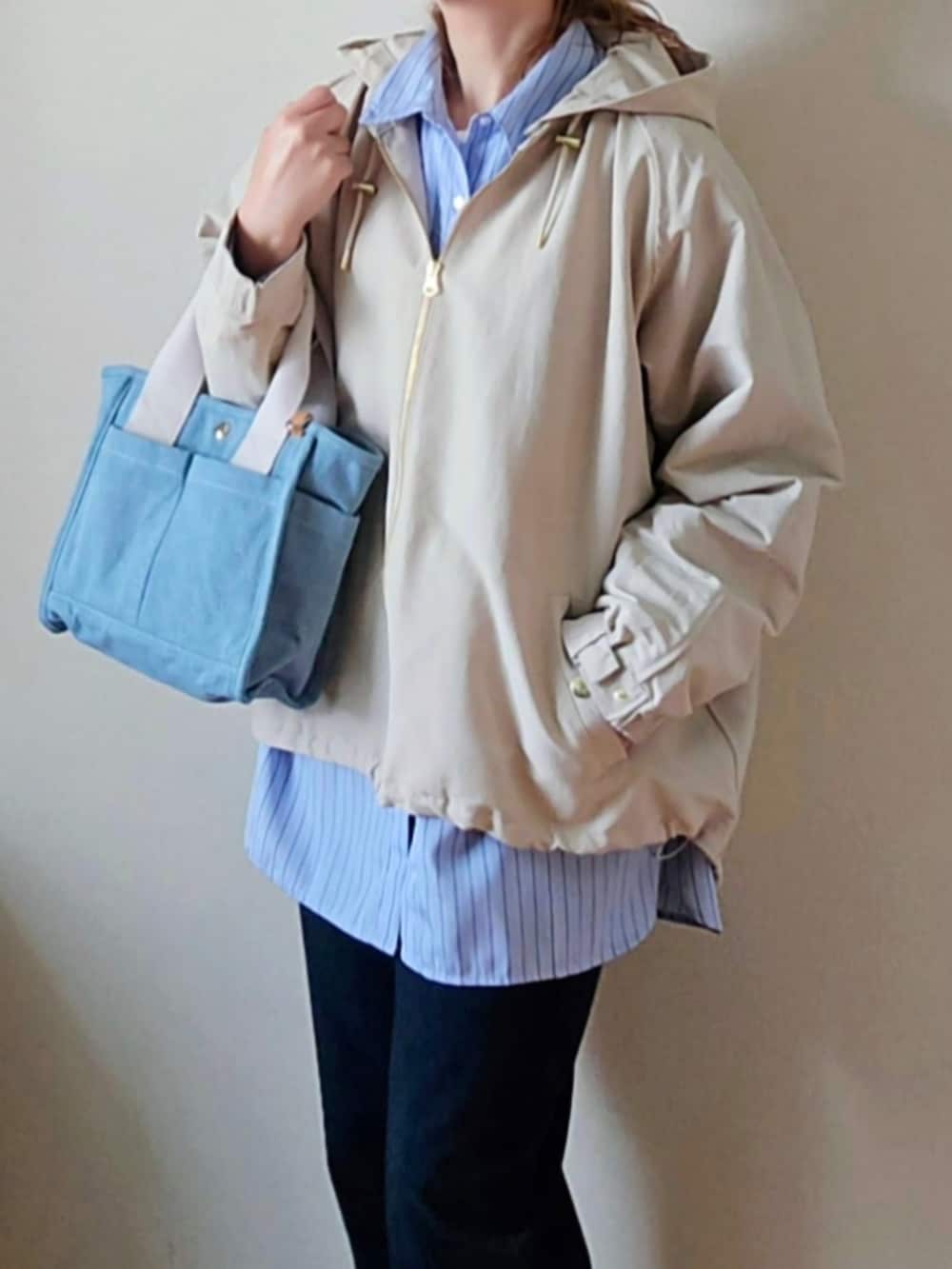 ブルー系のその他パンツ、ホワイト系のマウンテンパーカー、ブルー系のトートバッグを着用したレディースの春コーディネートの5枚目の写真