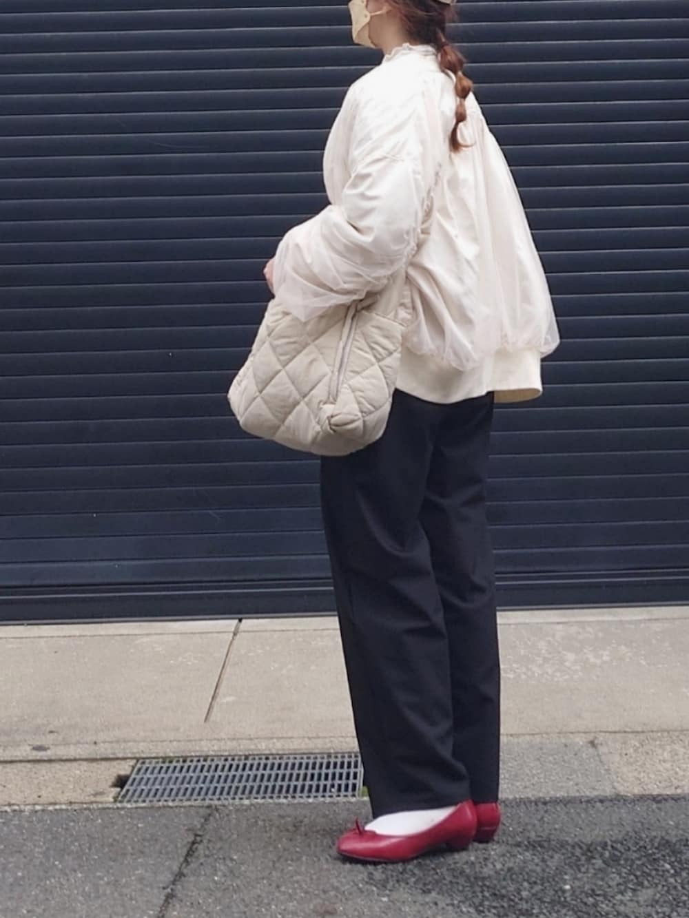 ホワイト系のブルゾン、ブラック系のスラックス、ホワイト系のカーディガン/ボレロを着用したレディースの春コーディネートの3枚目の写真