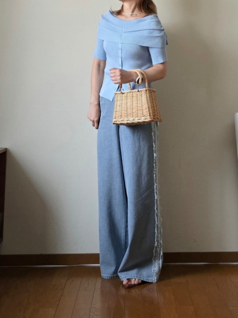 ブルー系のニット/セーター、ブルー系のデニムパンツ、ブラウン系のサンダルを着用したレディースの夏コーディネートの3枚目の写真
