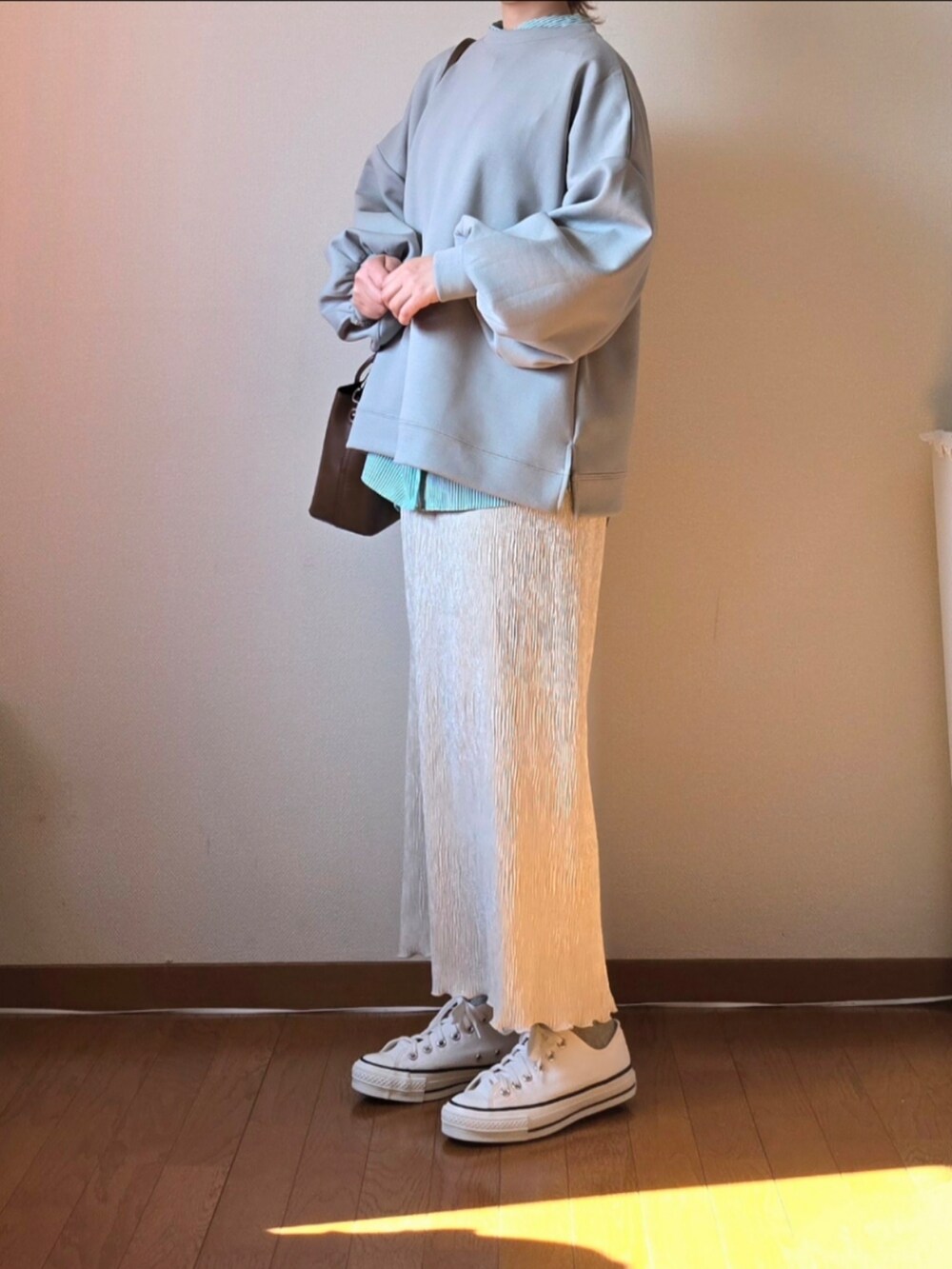 グリーン系のスウェット、グリーン系のシャツ/ブラウス、ホワイト系のスカートを着用したレディースの冬コーディネートの2枚目の写真