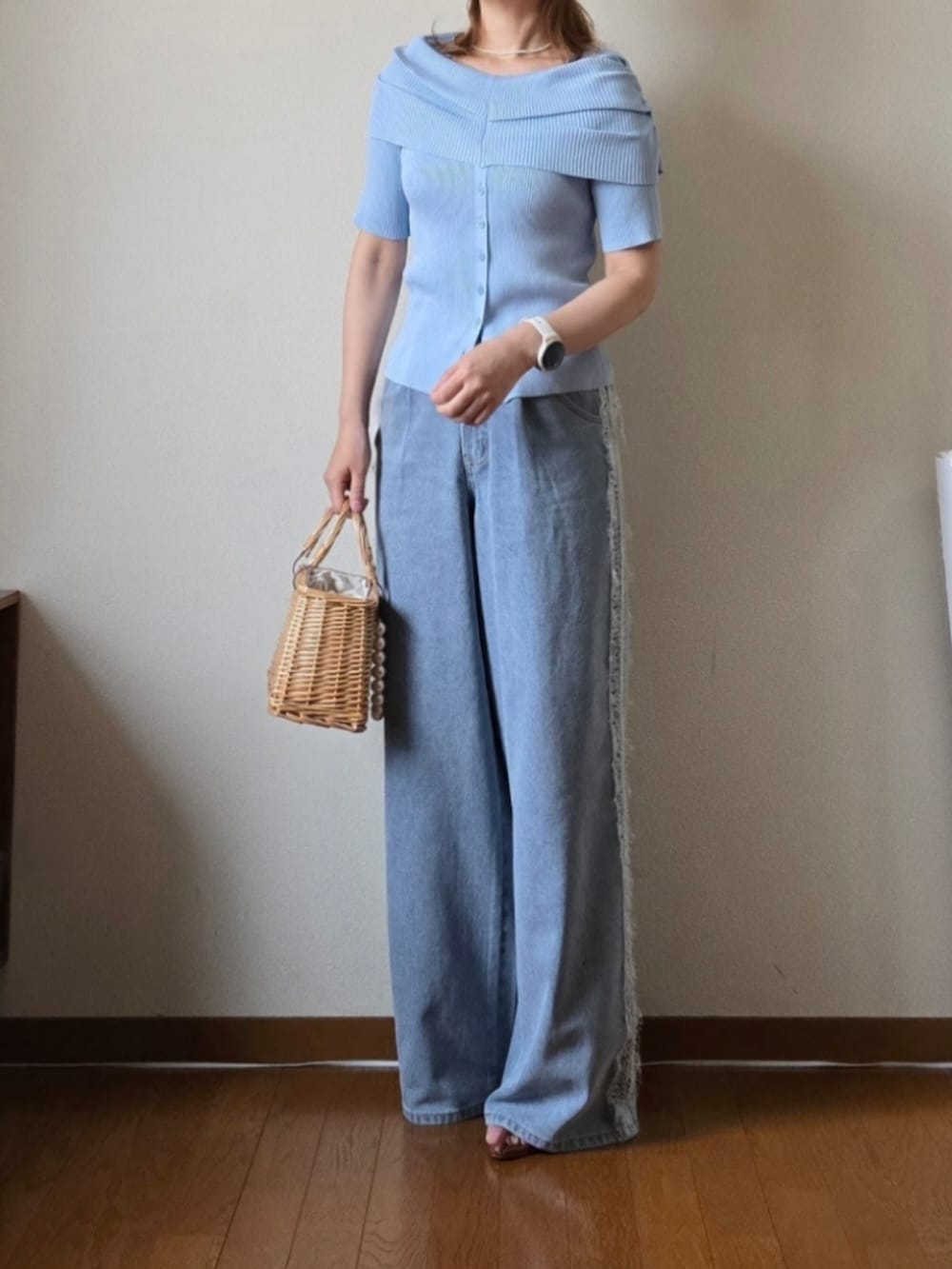 ブルー系のニット/セーター、ブルー系のデニムパンツ、ブラウン系のサンダルを着用したレディースの夏コーディネートの2枚目の写真