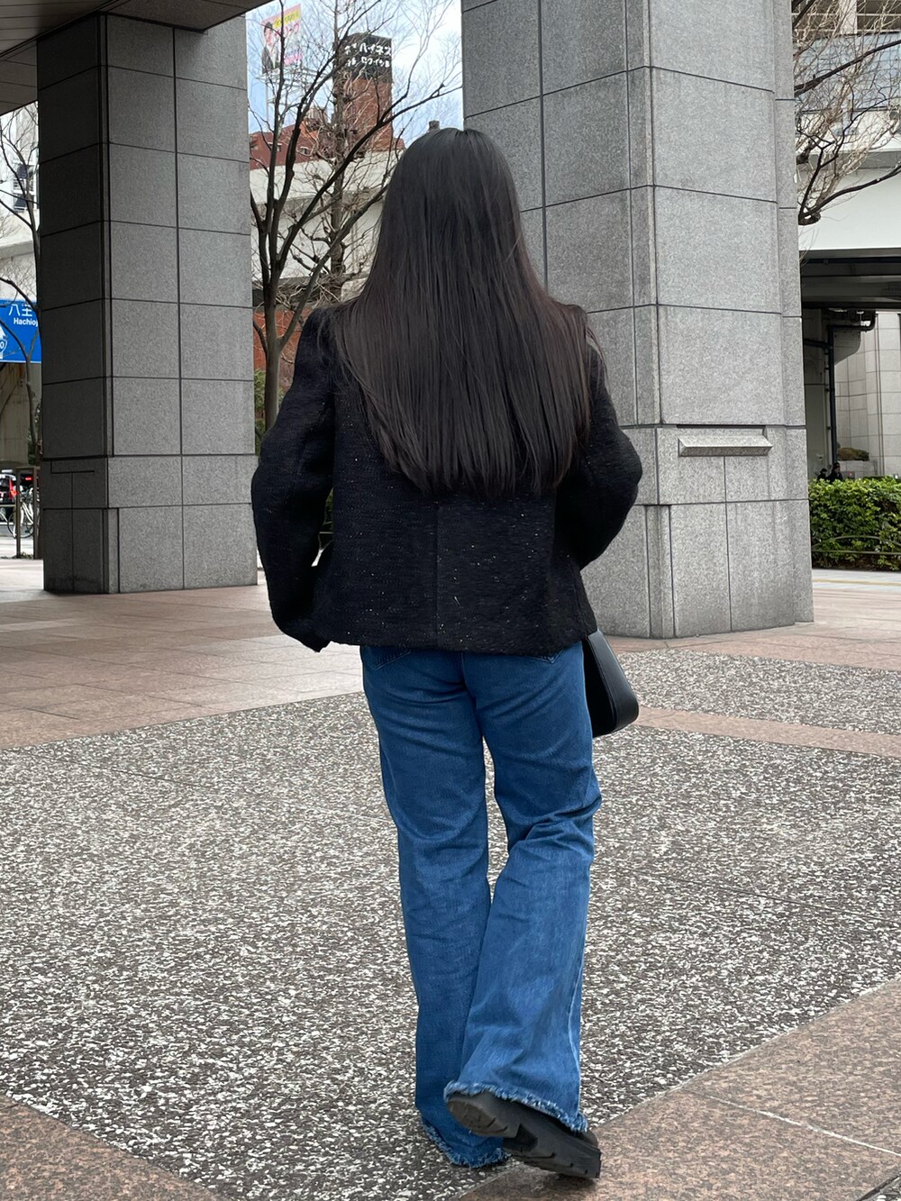 ブルー系のデニムパンツ、ブラック系のブーツ、ブラック系のニット/セーターを着用したレディースの冬コーディネートの3枚目の写真