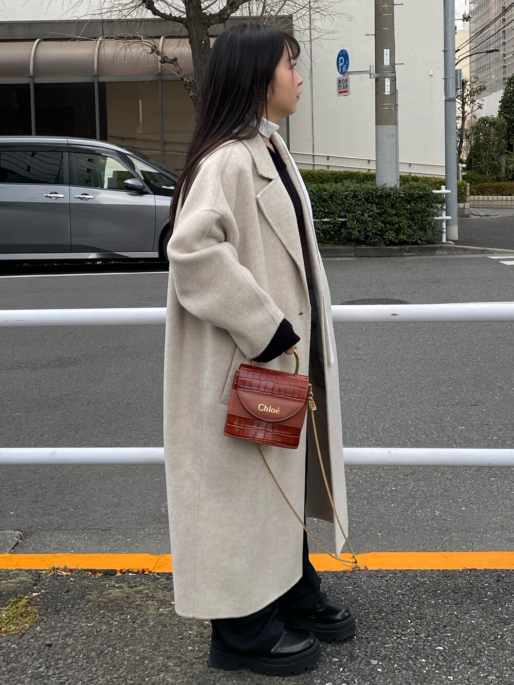 ブラック系のブーツ、ホワイト系のジャケット/アウター、ホワイト系のストール/ショールを着用したレディースの冬コーディネートの3枚目の写真