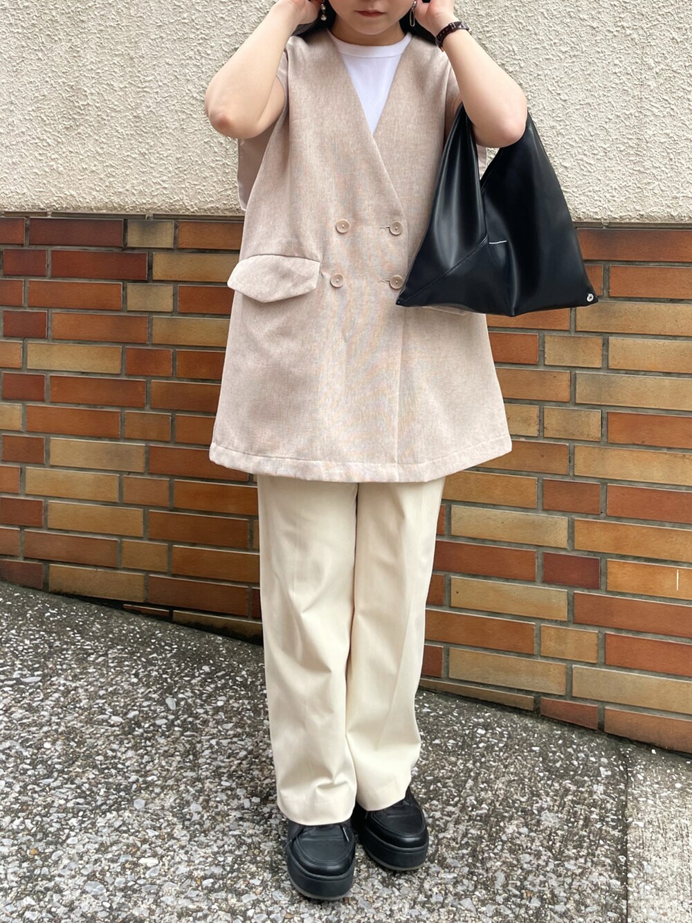 ホワイト系のタンクトップ、ベージュ系のベスト、ベージュ系のパンツを着用したレディースの秋コーディネートの2枚目の写真