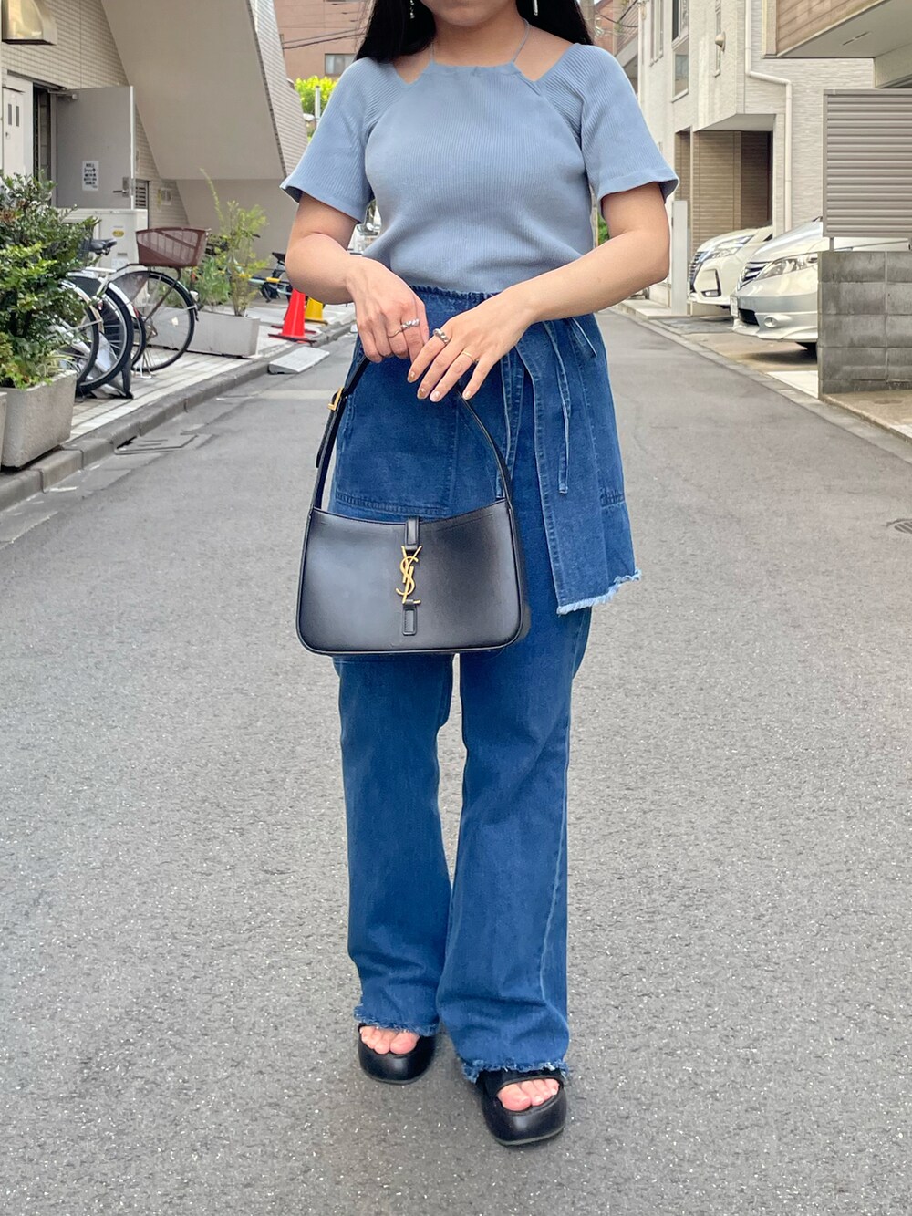 ブラック系のサンダル、ブルー系のデニムパンツ、ブルー系のTシャツ/カットソーを着用したレディースの秋コーディネートの2枚目の写真