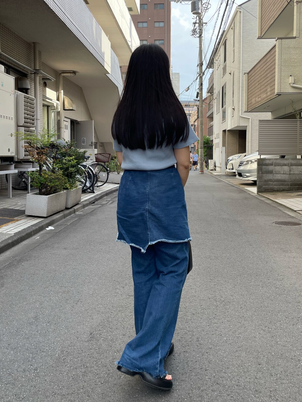 ブラック系のサンダル、ブルー系のデニムパンツ、ブルー系のTシャツ/カットソーを着用したレディースの秋コーディネートの3枚目の写真