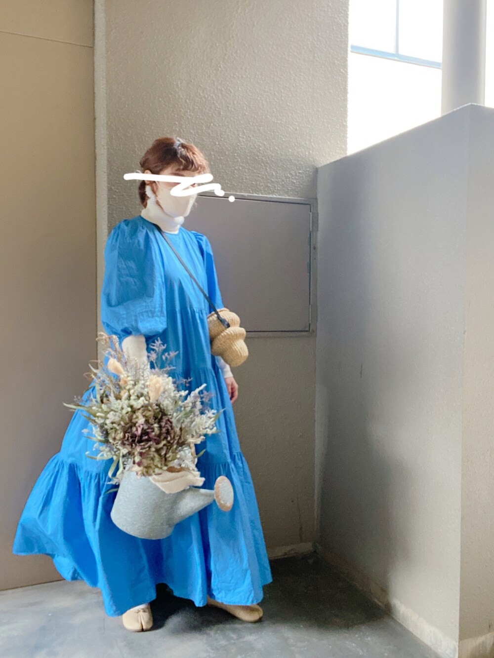 ブルー系のワンピース、ベージュ系のかごバッグを着用したレディースの春コーディネートの2枚目の写真