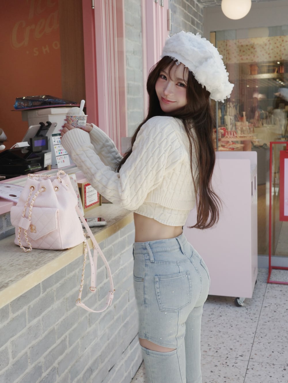 ホワイト系のワンピース、ブルー系のデニムパンツを着用したレディースの冬コーディネートの3枚目の写真