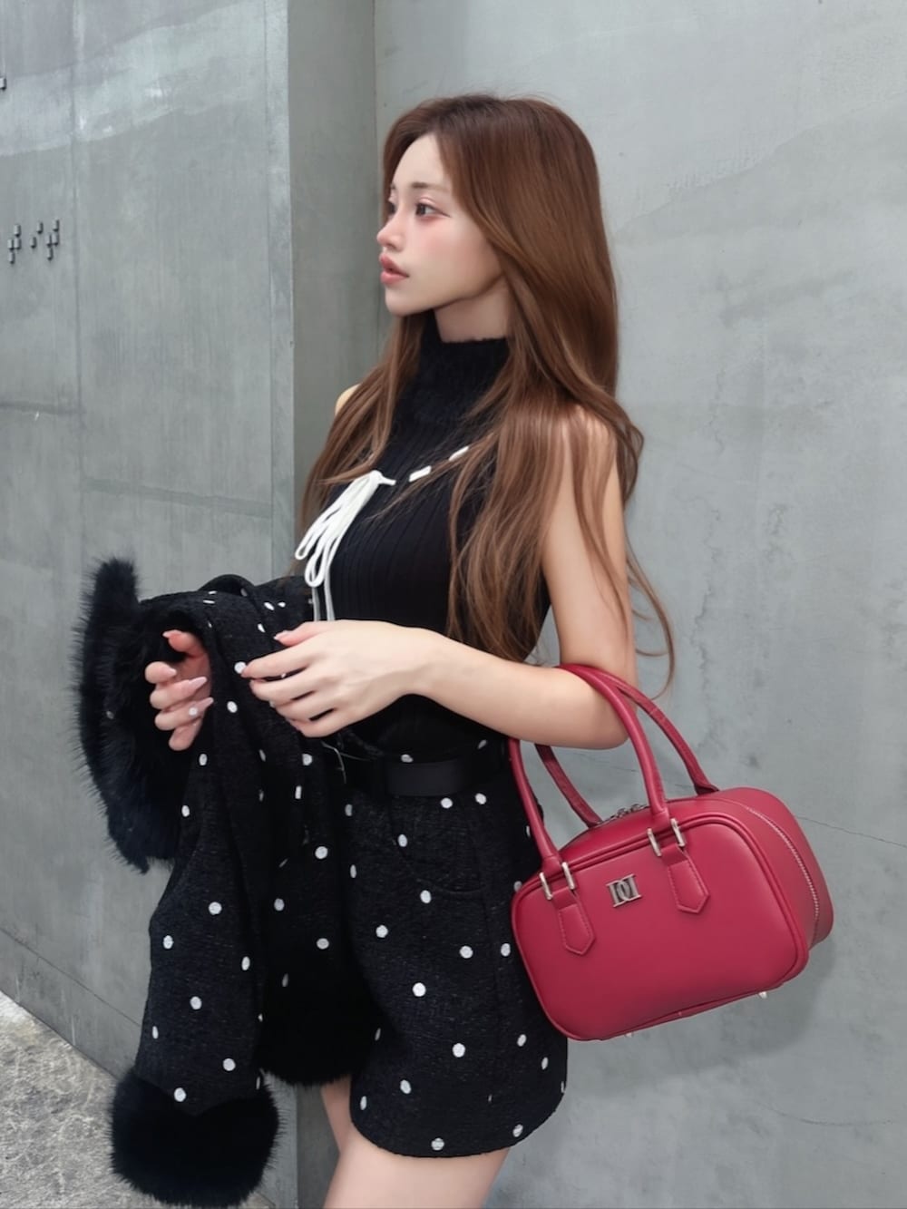 ブラック系のニット/セーター、ブラック系のブーツ、ブラック系のその他アウターを着用したレディースの秋コーディネートの2枚目の写真