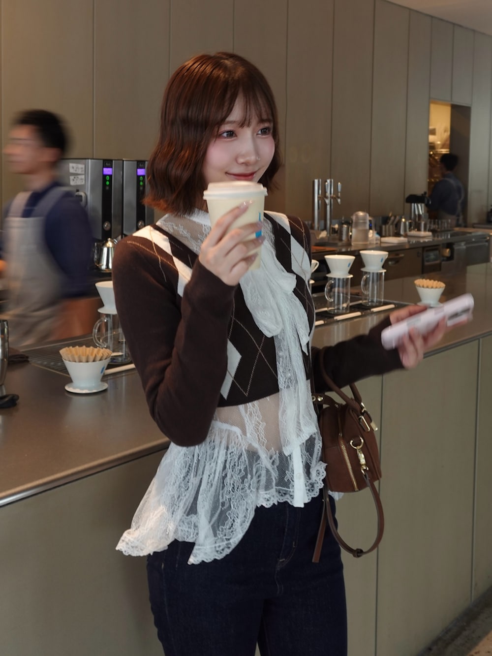 ブラウン系のニット/セーターを着用したレディースの夏コーディネートの2枚目の写真
