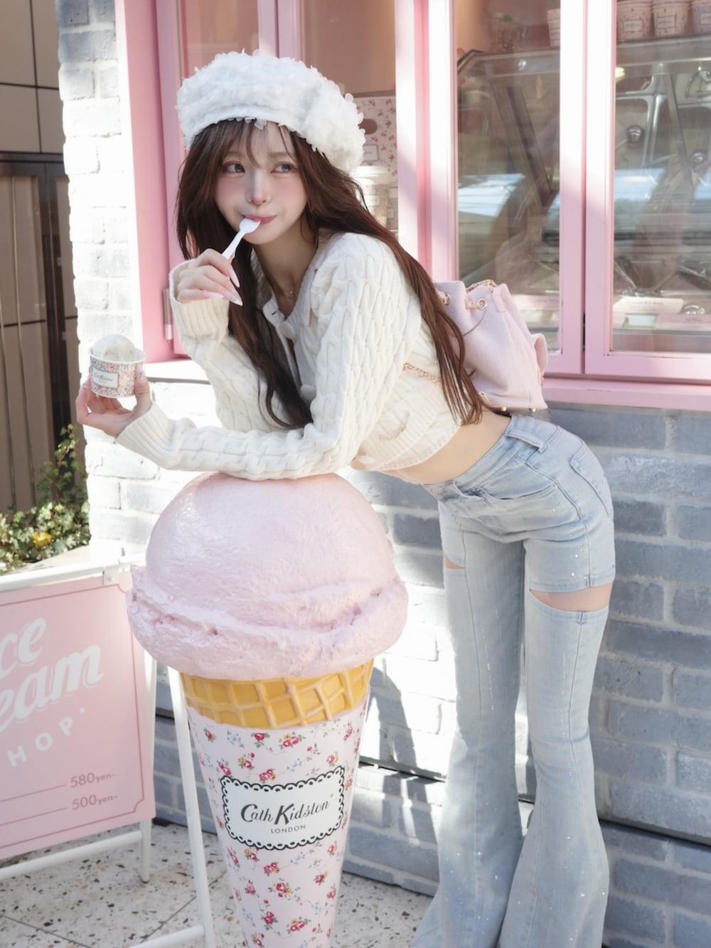 ホワイト系のワンピース、ブルー系のデニムパンツを着用したレディースの冬コーディネートの2枚目の写真