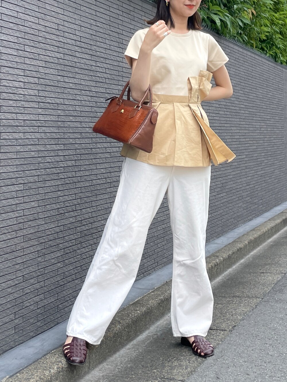 ベージュ系のデニムパンツ、レッド系のサンダル、ベージュ系のトップスを着用したレディースの夏コーディネートの2枚目の写真