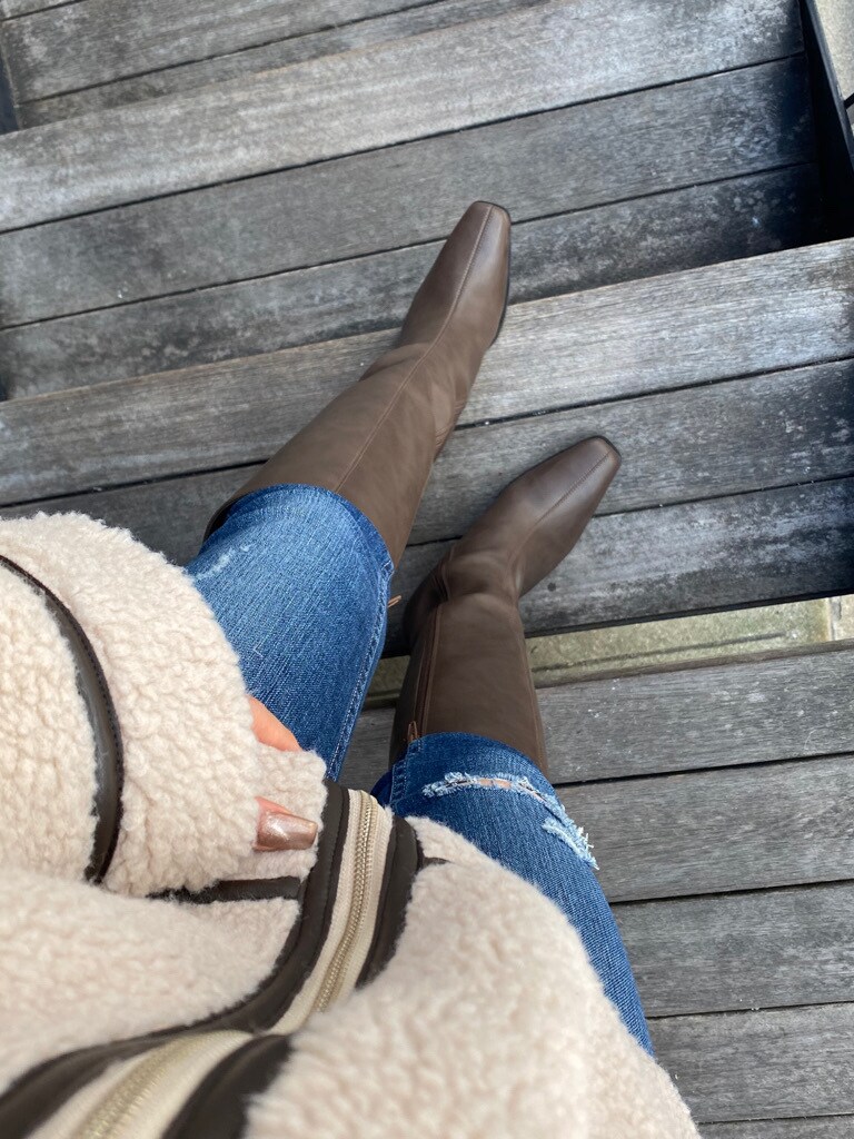 ブルー系のデニムパンツ、ブラウン系のブーツを着用したレディースの冬コーディネートの2枚目の写真