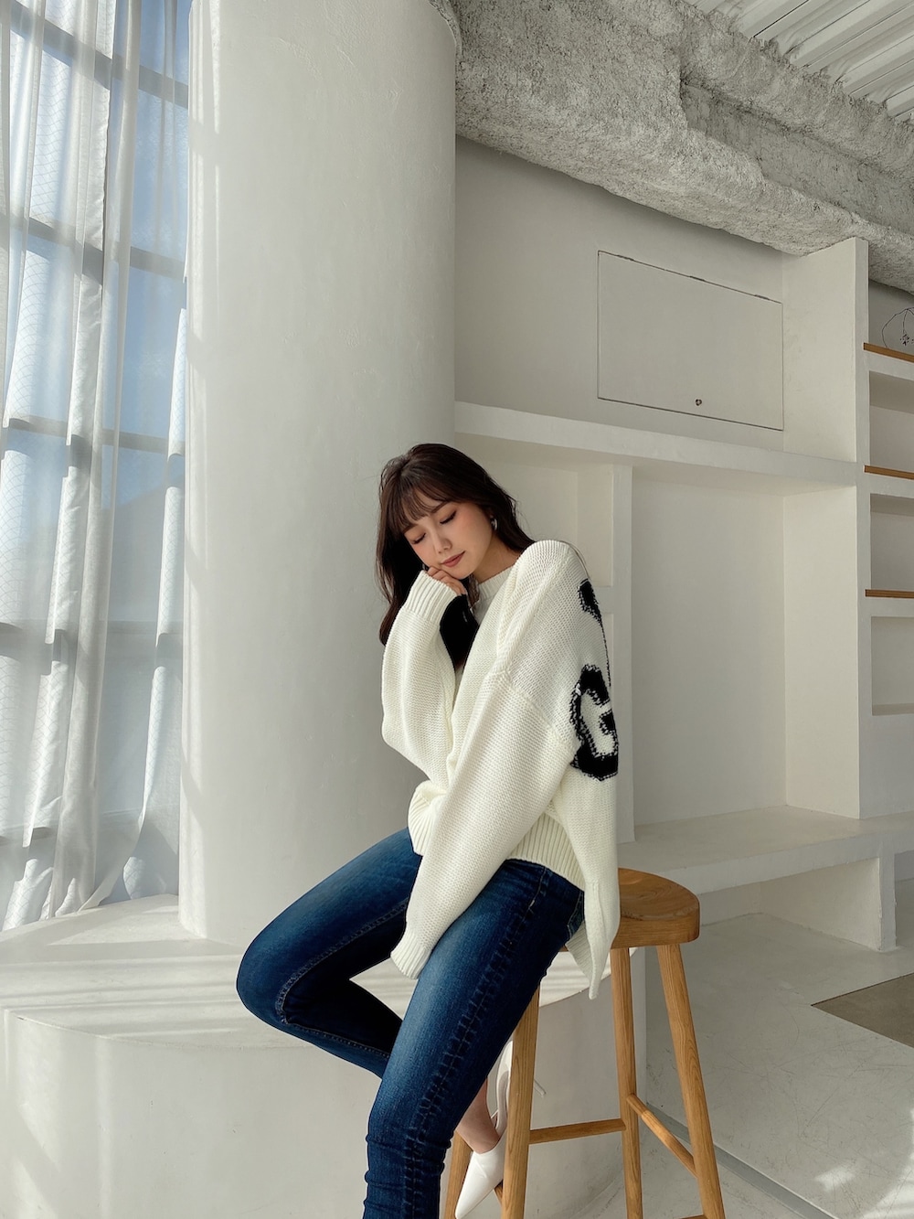 ホワイト系のニット/セーターを着用したレディースの冬コーディネートの2枚目の写真